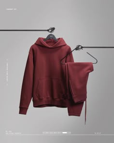 a red hoodie hanging on a clothes line next to an empty hanger with two pairs of scissors