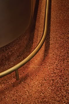 a close up of a metal object on a floor with red and gold speckles