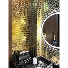 a bathroom with a mirror, sink and gold foiled wall paper on the walls