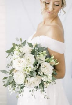 a woman holding a bouquet of white flowers