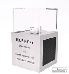 a white box with a golf ball in it that is on top of some sort of stand