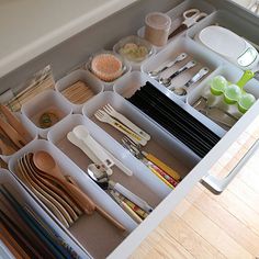 an organized drawer is shown with utensils and other kitchen items in the drawers