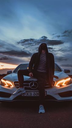 a man sitting on the hood of a car