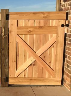 a wooden gate is shown with brick walls