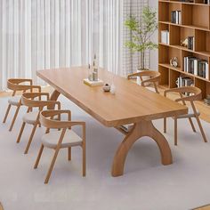 a dining room table with chairs and bookshelves