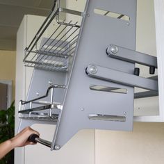 a person is pulling out the bottom part of a shelf