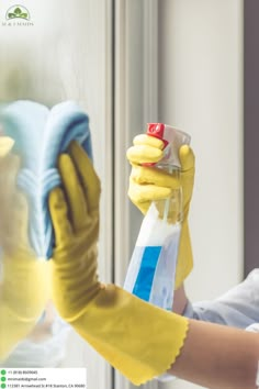 a woman in yellow gloves is cleaning the window with a rag and detergent bottle