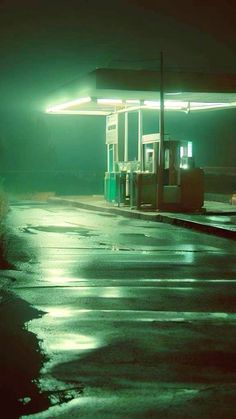 an empty gas station at night with the lights on