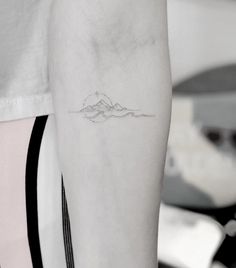 a woman's arm with a small tattoo on the left side of her arm