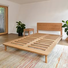 a bed sitting in the middle of a bedroom next to two planters and a window