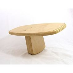 a wooden table sitting on top of a white surface with no one around it,