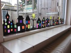 a window sill decorated with paper houses and trees