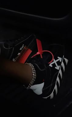 a person's black and white sneakers with red laces