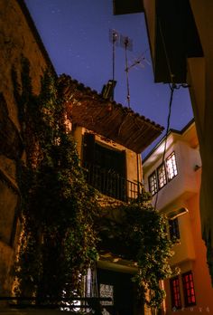 an old building with ivy growing on it's side and a satellite dish attached to the roof