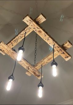 a light fixture made out of wooden beams and hanging from the ceiling with lights on it