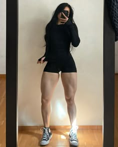 a woman taking a selfie in front of a mirror with her legs spread out