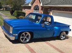 a blue truck parked in front of a house