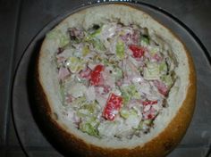 a close up of a pizza on a pan with tomatoes and lettuce in it