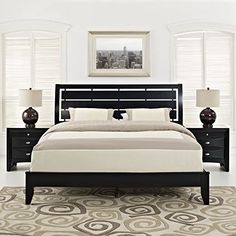 a bedroom with white walls and black furniture