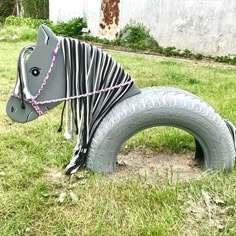 a toy horse made out of an old tire is tied to the ground with a rope