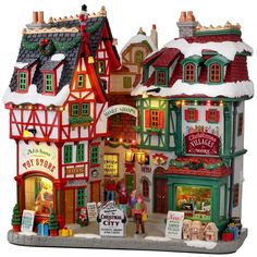 a christmas village with lights and decorations on the front, including shops and storesfronts