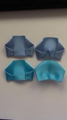 three pieces of paper folded in the shape of boats