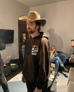 a man wearing a cowboy hat standing in a living room