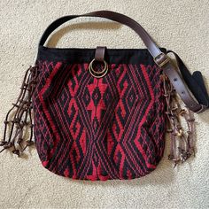 Jadetribe - Nicole Messenger Bag - Red & Black - Never Used But No Tag - 6 Brown Leather Tassels On Each Side. - Snap Closure - Adjustable Belt Strap With 5 Hole Selections - Inside Is Black, Includes One Pocket. - Made In Thailand. This Hand Woven Messenger Bag Is Created From Organic Cotton And Natural Dyes. - Has A Scratch On The Clasp. Seen In Photo But From A Distance It Is Faint. - Including 2 Stock Photos Of A Different Color. Approximately L15 X H15 X W3 Inches 36” - Strap On Shortest Se Bohemian Shoulder Bag With Detachable Strap For Travel, Woven Hobo Shoulder Bag For Travel, Red Shoulder Bag With Leather Handles For Market, Travel Hobo Shoulder Bag With Woven Details, Bohemian Satchel With Detachable Strap For Travel, Bohemian Travel Satchel With Detachable Strap, Bohemian Travel Bag With Detachable Strap, Black Handwoven Festival Bag, Traditional Bucket Bag With Adjustable Strap For Everyday