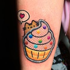 a cat sitting on top of a cupcake with sprinkles