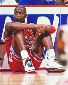 a basketball player sitting on the floor with his feet up