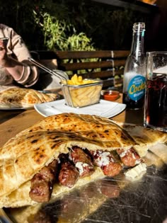 two people sitting at a table with food and drinks