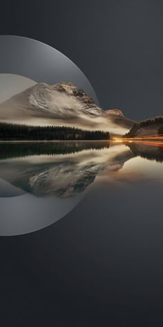 an image of mountains and trees reflected in the water