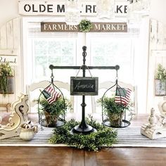 a wooden table topped with potted plants and an old fashioned scale on top of it