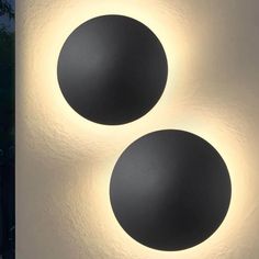 two black round lights on a white wall