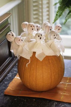 a pumpkin decorated with ghost decorations on top of a table