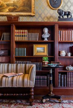 a room with bookshelves, chairs and pictures on the wall