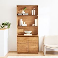 a white chair sitting next to a wooden cabinet