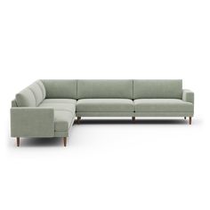 a large sectional couch sitting on top of a white floor next to a wooden leg chair