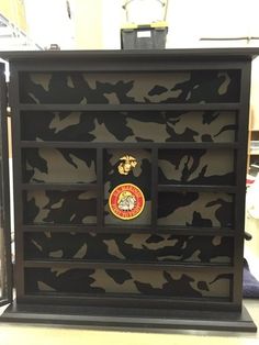 a black and white cabinet with an army emblem on it's front door is shown