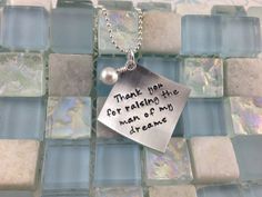 a silver necklace with a quote on it that says thank you for raising the man of my dreams