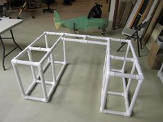 a white pipe structure sitting on top of a floor next to a table and chairs