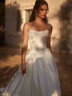 a woman in a white wedding dress standing outside