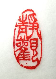 a red and white embroidered object with chinese writing on it