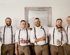 a group of men standing next to each other wearing brown pants and bow ties with beer cans in their hands