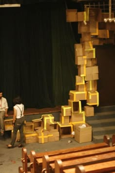 two people standing in front of boxes on a stage