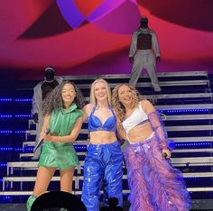 three women standing on stage with one holding a microphone