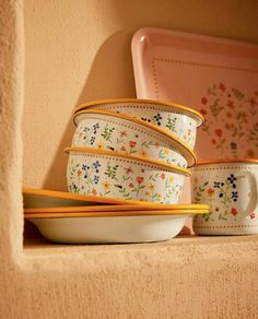 a stack of bowls sitting on top of a shelf next to a plate and bowl