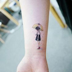 a girl with an umbrella tattoo on her wrist is holding the hand of another person