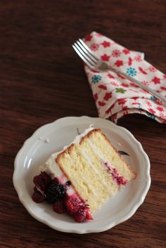 a piece of cake on a white plate with berries