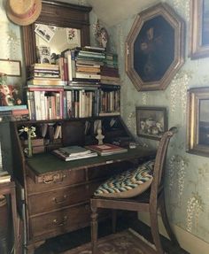 a desk with a chair, bookshelf and pictures on the wall